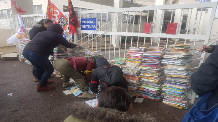 Els activistes amunteguen els vells manuals escolars bloquejant l'accés a la DSDEN